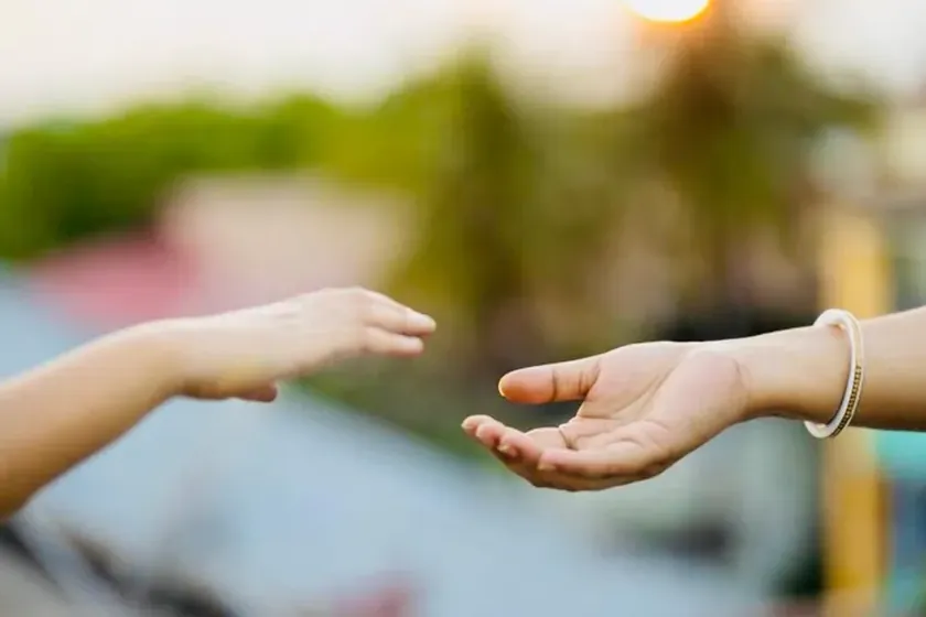 Deux mains qui se tendent l'une vers l'autre — séance de relation d'aide