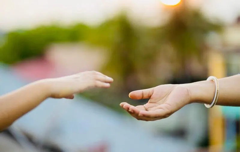 Deux mains qui se tendent l'une vers l'autre — séance de relation d'aide